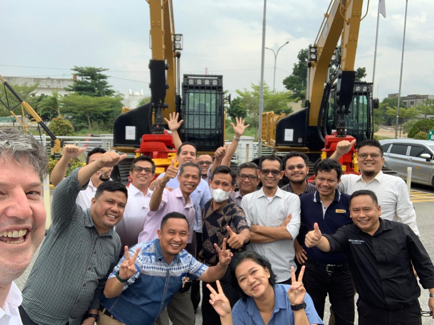 Aftermarket Field Sales team posing with excavators in Bangkok, Thailand